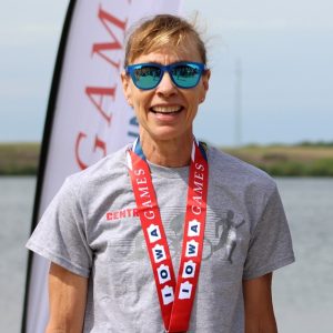 Profile picture of Julie Summers. She is standing and smiling with an Iowa Senior Games medal around her neck.